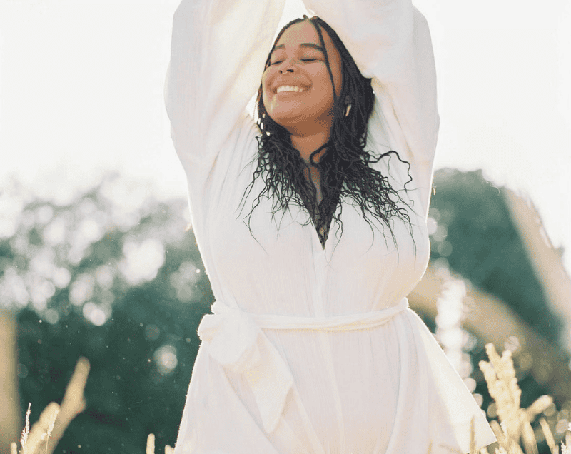 confident woman smiling and dancing in a field